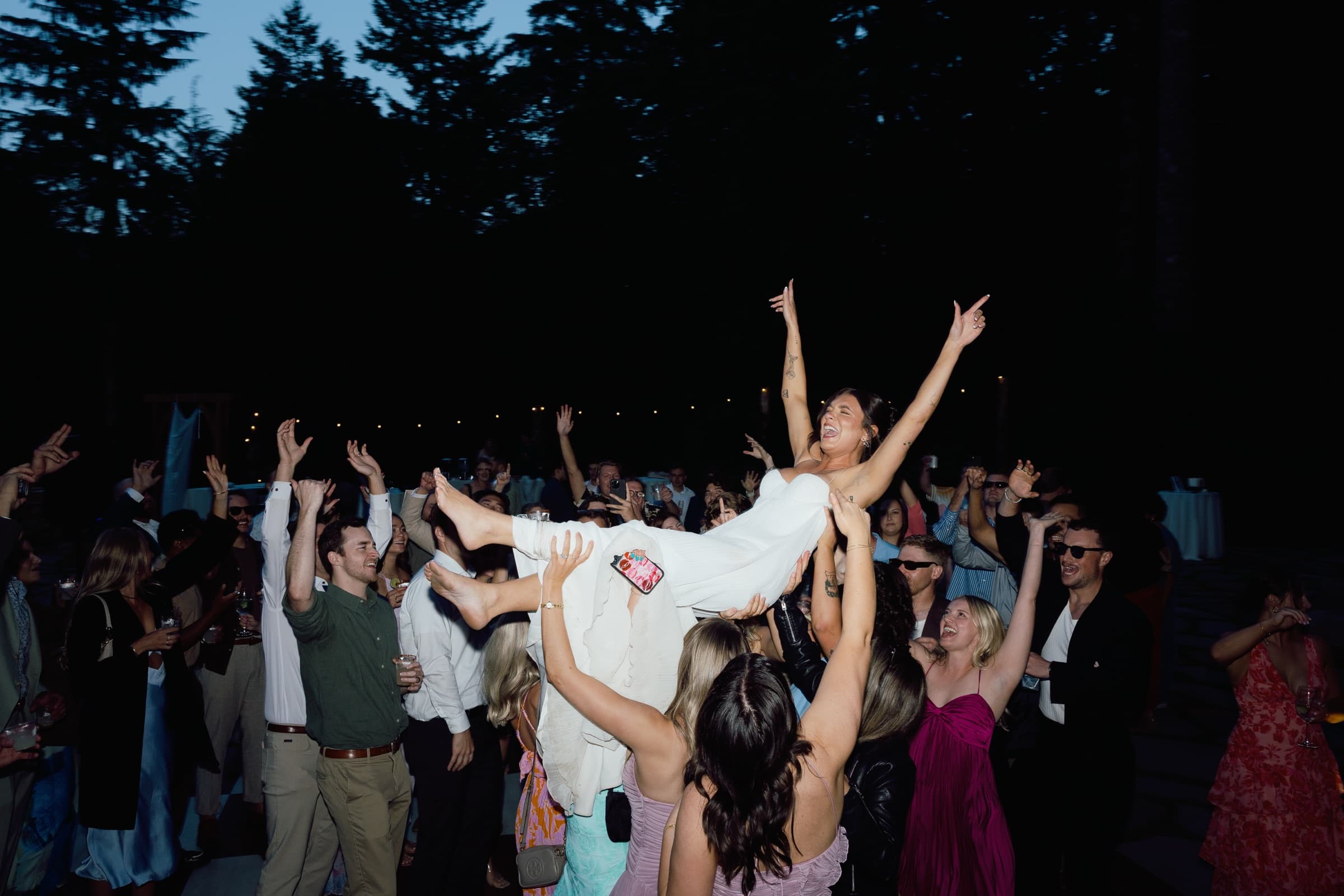 Bride crowd surfing at outdoor dance floor
