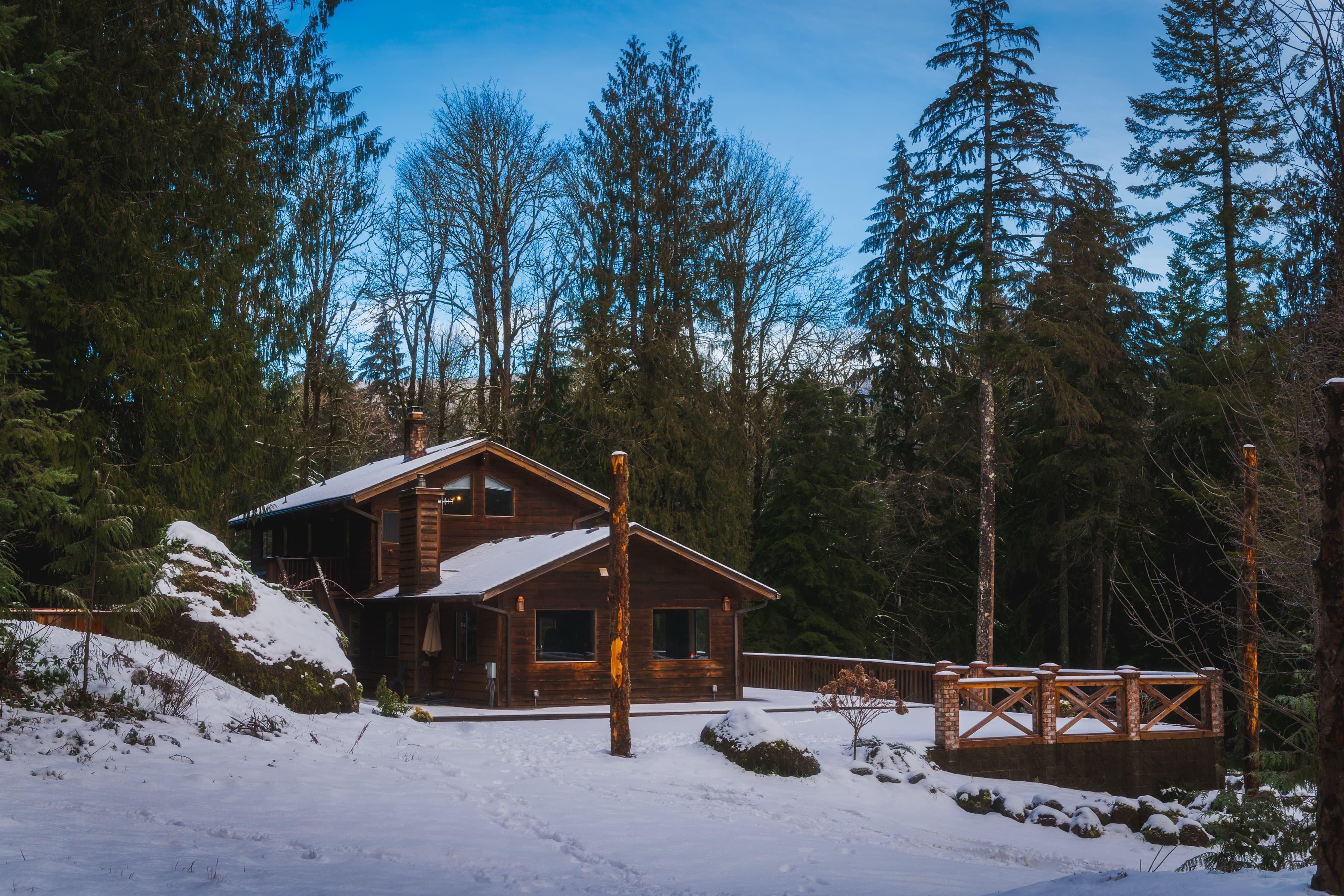 Cottage exterior in winter snow among the evergreens