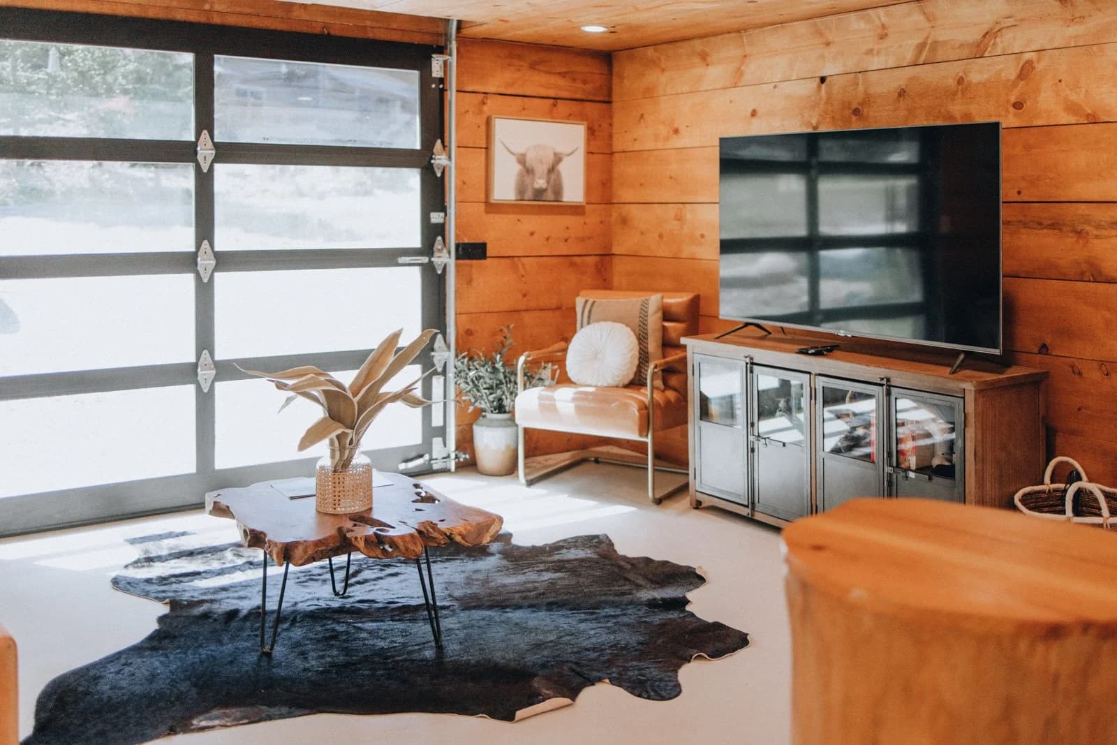 Living room with garage door and forest views