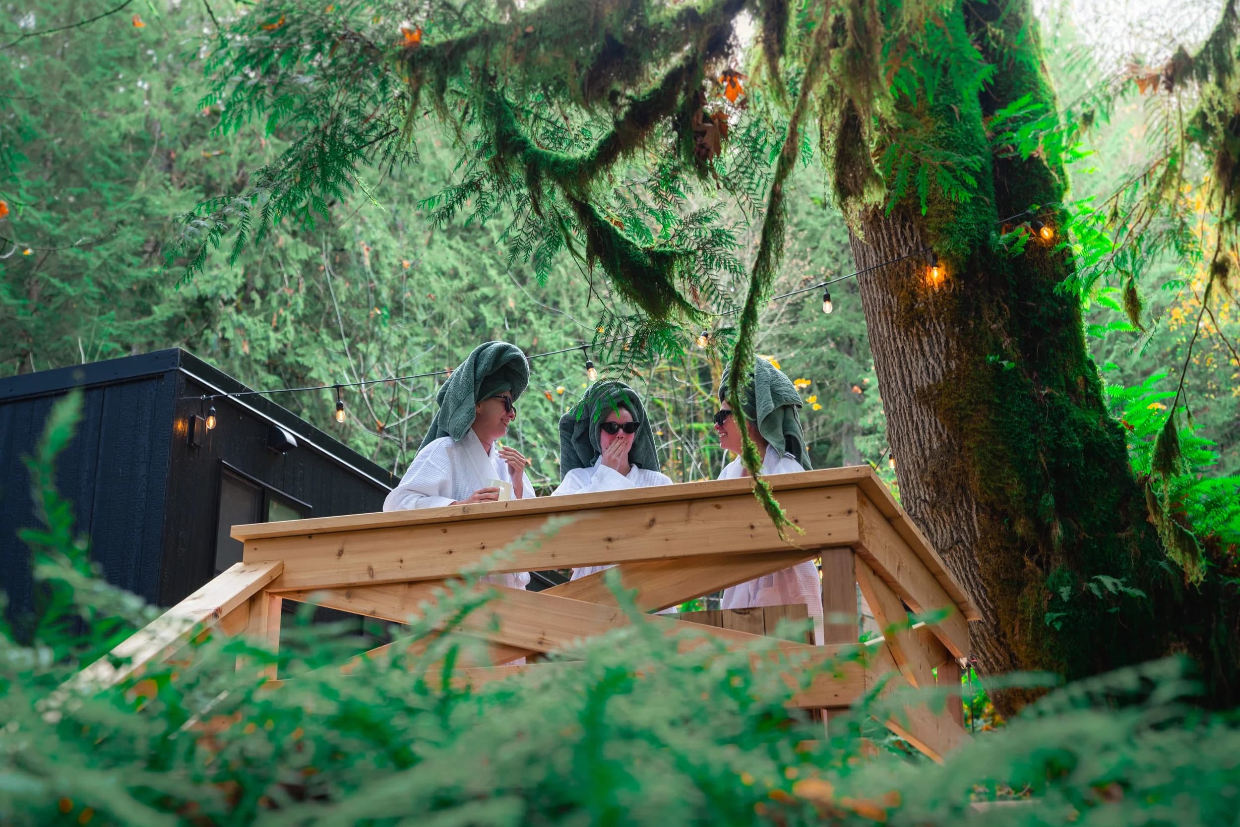 Guest soaking in the cedar cold plunge surrounded by old-growth forest
